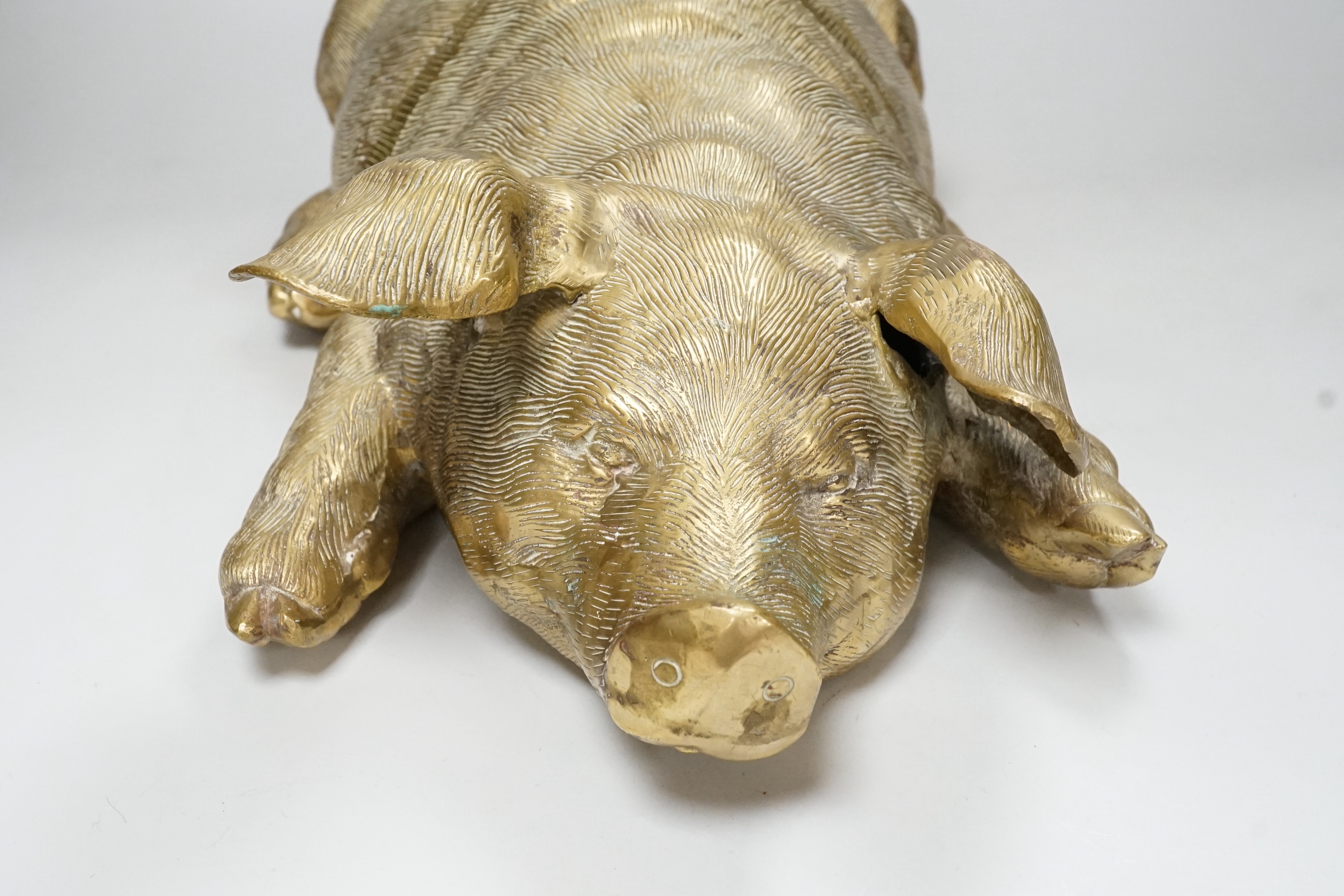 A large hollow cast brass model of a recumbent pig, 47cm long